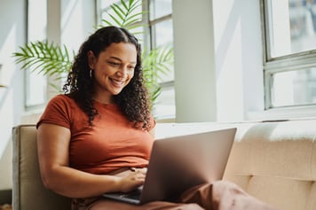 women using laptop on couch - healthcare equity
