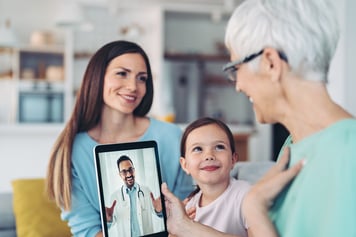 Grandmother, mother and daughter in a video call with a doctor 