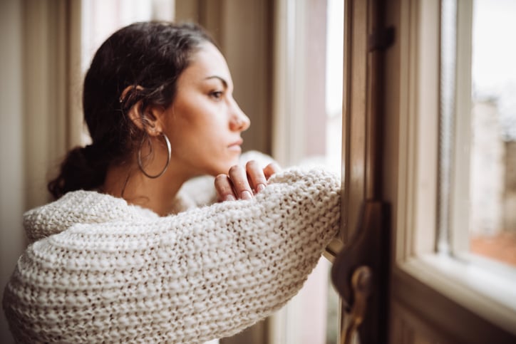 Pensive woman in front of the window stock photo