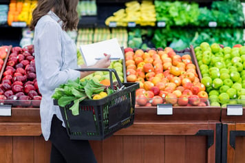 Unrecognizable woman shops for produce in supermarket stock photo