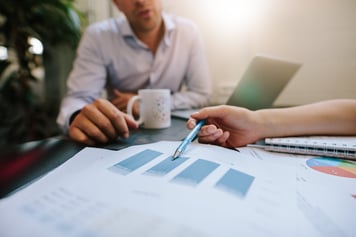 Coworkers reviewing data together on paper docuemnts