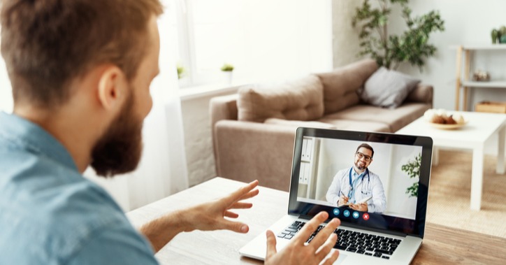 Person smiling at doctor on computer virtual care