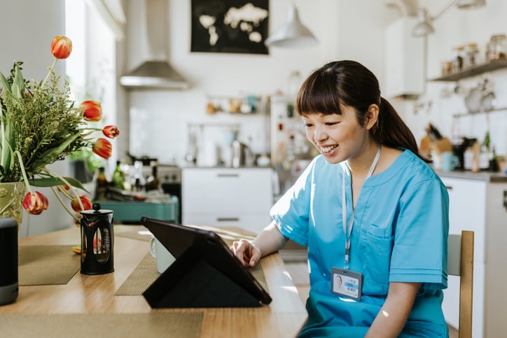 First Stop Health doctor smiling at tablet for consultation