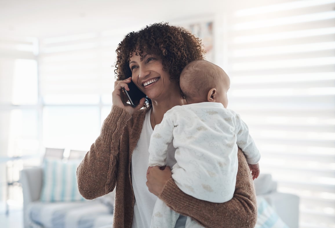 Woman on phone smiling during virtual primary care doctor visit